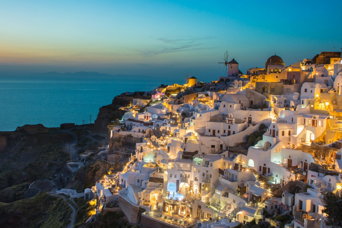 Whitewashed houses lit at dusk above the sea in Greece