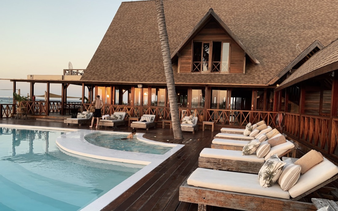 Sun loungers beside a resort pool at dusk
